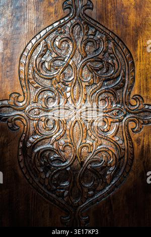 Detailed view of an intricately carved wooden door in Marrakech, Morocco, showcasing traditional Moroccan artistry and craftsmanship, perfect for cult Stock Photo