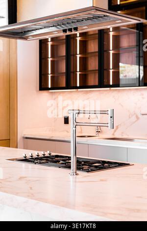A sleek modern kitchen showcasing luxurious marble countertops, stainless steel appliances, and elegant cabinetry lighting, epitomizing contemporary s Stock Photo