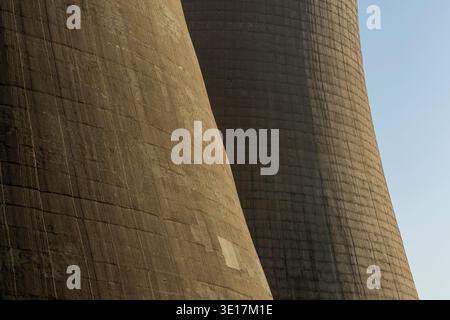 Close-up view of massive concrete cooling towers from an industrial plant basking in soft sunlight, showcasing the texture and architecture of modern Stock Photo