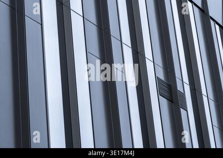 Close-up view of a modern glass office facade showcasing sleek architectural lines. The reflective surface enhances the contemporary design of this fi Stock Photo