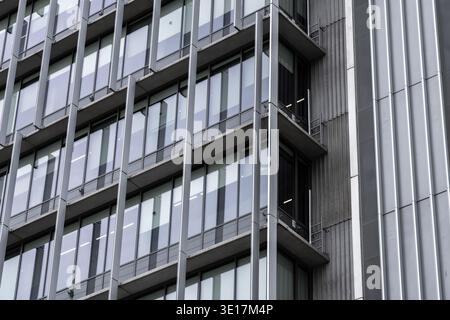 Close-up of a modern corporate building featuring a sleek glass facade. The architectural design highlights vertical lines and reflective surfaces, em Stock Photo