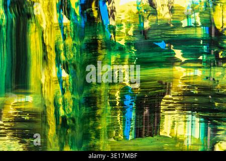 A vibrant abstract background created with acrylic paint, featuring dynamic strokes in shades of green, yellow, and blue. This artwork evokes energy a Stock Photo