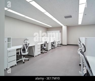 Open office with white workstations and bright daylight. Stock Photo