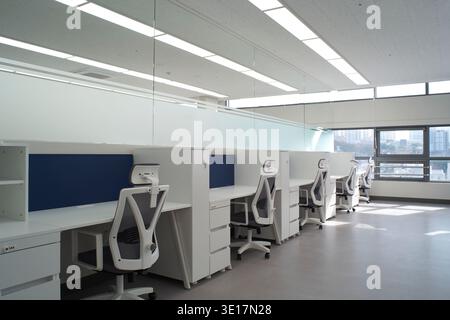 Open office with white workstations and bright daylight. Stock Photo
