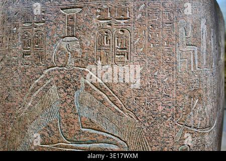 Close-up view of an ancient Egyptian granite sarcophagus featuring intricate hieroglyphic inscriptions and carved relief imagery. The... Stock Photo
