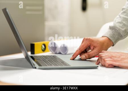 Engineering working with drawings inspection on laptop in the office.Engineer, Architect, Industry and factory concept. Stock Photo