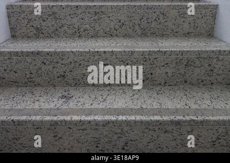 Each step rises gently with defined edges and subtle grain. Light reflects off polished surfaces, creating soft shadows. Large size granite staircase Stock Photo