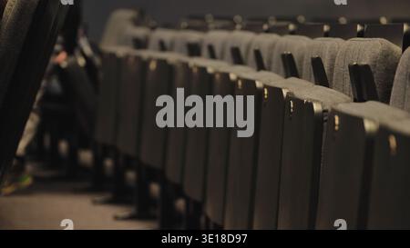 Diagonal row of empty seats in a dark theater auditorium Stock Photo