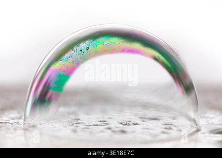 Soap bubble showing rainbow colors on a wet underground Stock Photo