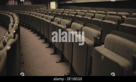 Empty seats curving in an auditorium, highlighting the concept of vacancy and waiting Stock Photo