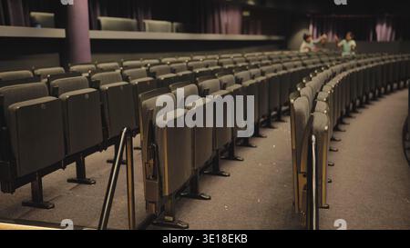 Empty seats in curved rows inside a dark modern theater auditorium Stock Photo