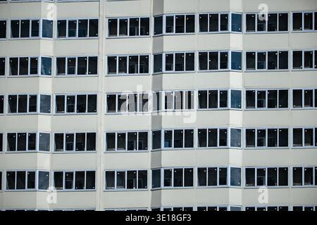 Building facade featuring many windows creating a modern architectural pattern Stock Photo