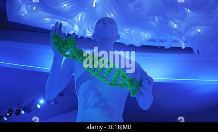Human figure holding DNA strand in a blue illuminated science exhibition Stock Photo