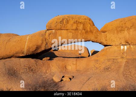 Morning, woman standing in rock arch, Pontok Mountains, Grosse Spitzkoppe, Spitzkoppe, Grosse Spitzkuppe Nature Reserve, Namibia Stock Photo