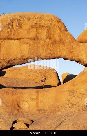 Morning, woman standing in rock arch, Pontok Mountains, Grosse Spitzkoppe, Spitzkoppe, Grosse Spitzkuppe Nature Reserve, Namibia Stock Photo