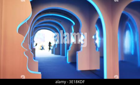 Row of human face profile arches forming an illuminated tunnel at an exhibition Stock Photo