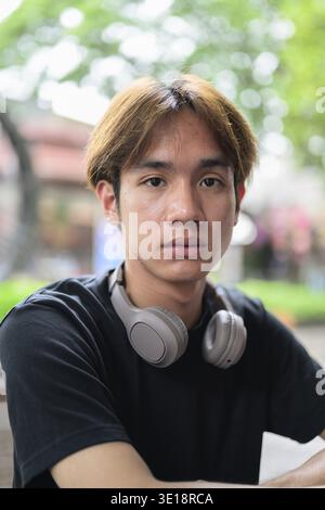 Portrait of a young Thai Asian man in casual style posing for modern lifestyle photography. Confident, relaxed, and authentic look suitable for variou Stock Photo