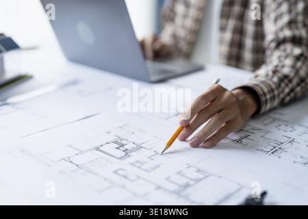 Architectural Drawing of Building Project with Colleagues Designing Blueprint Using Compasses Stock Photo