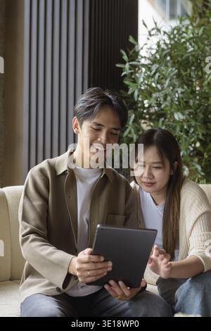 Couple using digital tablet computer in cafe while having coffee Stock Photo
