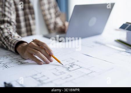Architectural Drawing of Building Project with Colleagues Designing Blueprint Using Compasses Stock Photo