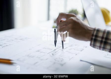 Architectural Drawing of Building Project with Colleagues Designing Blueprint Using Compasses Stock Photo