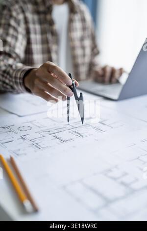Architectural Drawing of Building Project with Colleagues Designing Blueprint Using Compasses Stock Photo