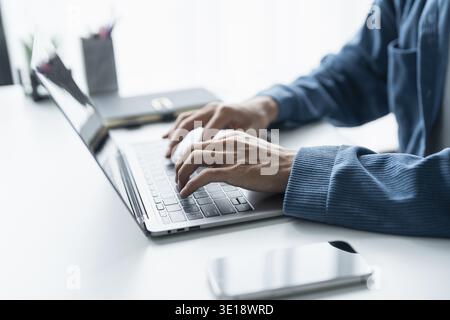 Man working by using a laptop computer Hands typing on keyboard. writing a blog. Working at home are in hand finger typewriter Stock Photo