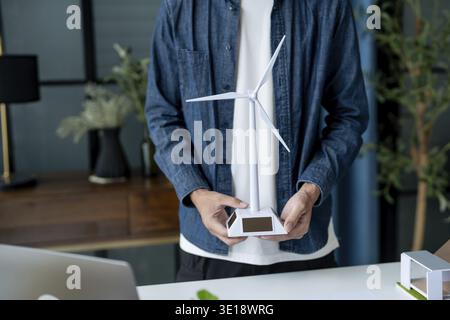 Businessman and Engineers Working on Solar Panels Project for Green Energy Accumulation in Eco-Friendly Office Stock Photo