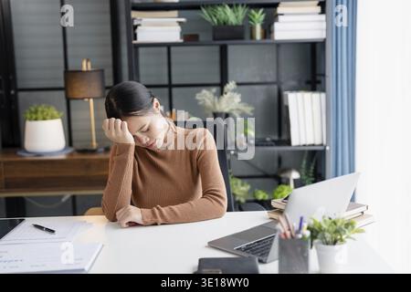 Stressed Asian Businesswoman Burnout tired with headache in office Stock Photo