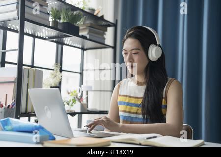 Asian woman using laptop to study student engaged in online learning Stock Photo