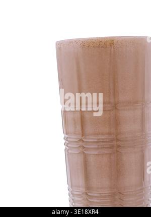 A tall glass filled with a rich, creamy chocolate drink sits on a table. The beverage appears chilled and inviting, perfect for a warm afternoon refre Stock Photo