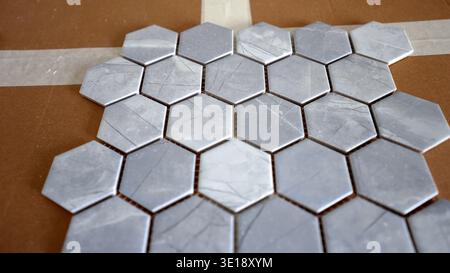 Hexagonal ceramic tiles with a honeycomb pattern, outlining intricate design details. Ceramic tiles glued to the wall. Stock Photo