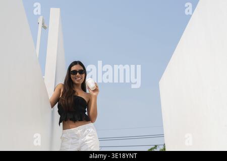 Beautiful Asian woman outdoors during sunny day wearing sunglasses Stock Photo