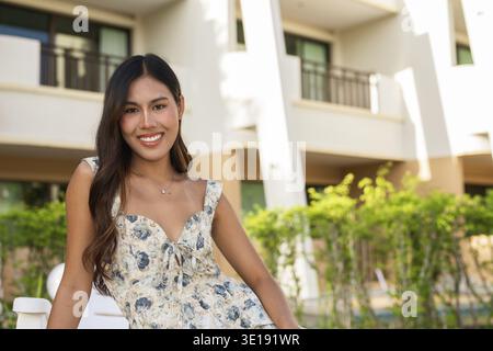 Young happy woman sitting outdoors during summer Stock Photo