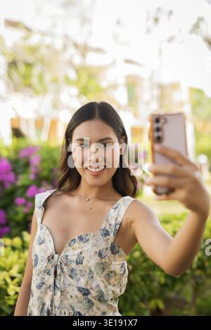 Young Asian woman using phone outdoors Stock Photo