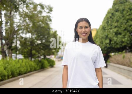 Young Thai Woman Smiling Outdoors in Casual Clothing Concept Stock Photo