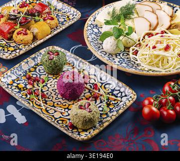 Pkhali, cheese, vegetables and other dishes of georgian cuisine are served on a table with a blue tablecloth Stock Photo