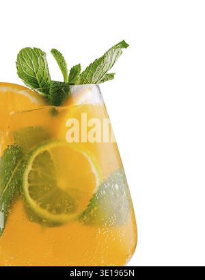 Glass of refreshing orange cocktail with lime slices, ice cubes and fresh mint leaves Stock Photo