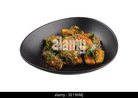 Spicy fried bitter melon with chili garlic sauce served on a black plate, isolated on a white background Stock Photo