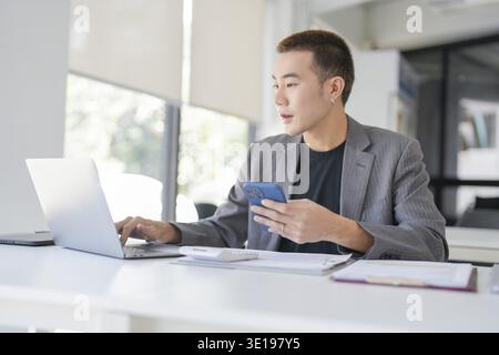 Asian Business man working with laptop. Young business man thinking Concentrated at work Stock Photo