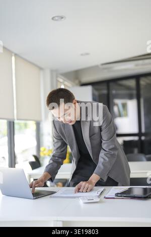 Young business man busy standing work at office. businessman using computer laptop business management concept Stock Photo