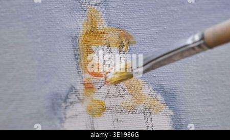 Artist painting on canvas with brush and yellow oil paint Stock Photo