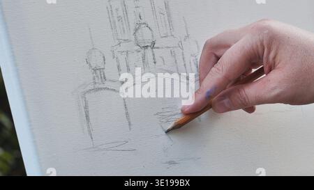 Artist hand sketching famous Moscow cathedral using pencil on canvas outdoors Stock Photo