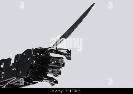 Real robot's hand with steak knife. Concept of AI development and robotic process automation Stock Photo