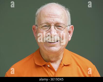 Portrait of grey haired senior man with mustache wearing eyeglasses and smiling Stock Photo
