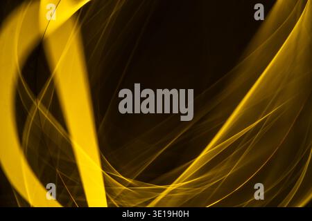 Golden energy streams and glowing light trails flow across a dark background, forming dynamic, fluid patterns and vibrant, futuristic textures suggest Stock Photo