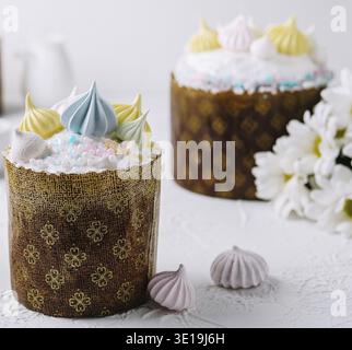 Handcrafted traditional easter cakes adorned with vibrant meringue on a festive table setting Stock Photo
