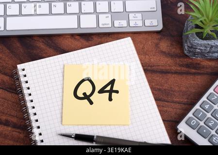Q4 text on adhesive note 4th Quarter financial report with calculator business concept Stock Photo