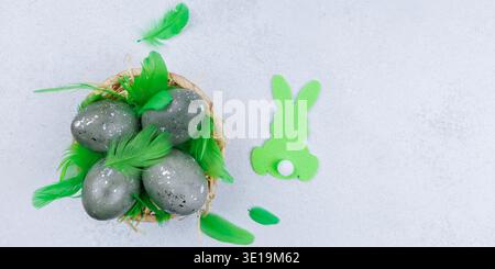 Decorative easter eggs with green feathers and bunny shape Stock Photo