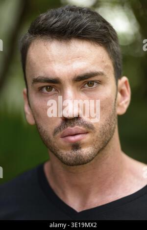 Portrait of handsome bearded Persian man in the park outdoors Stock Photo